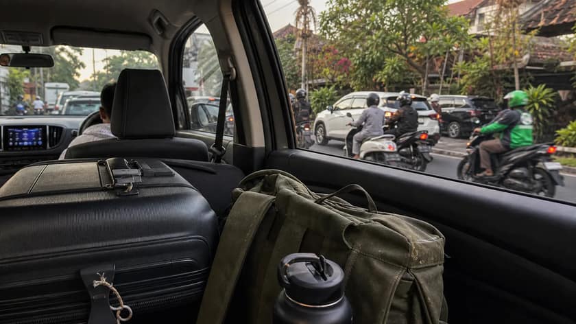 Illustrated Bali Airport to Canggu route with traffic, luggage and villa pin logistics.
