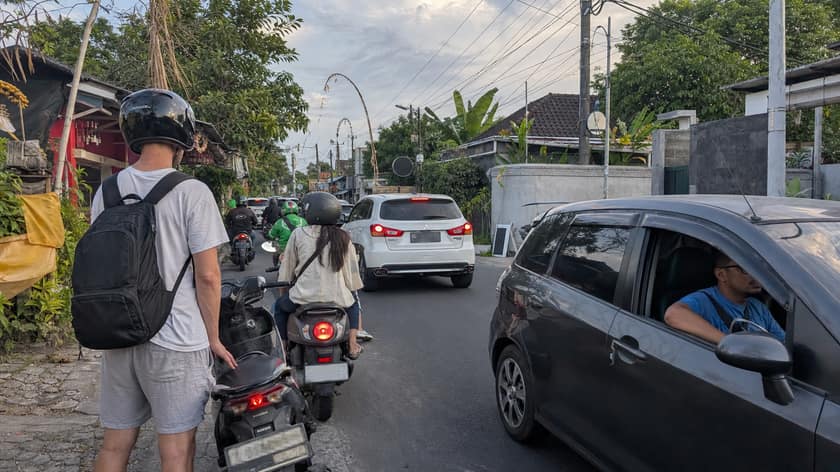 Scooters and cars moving through everyday Bali traffic
