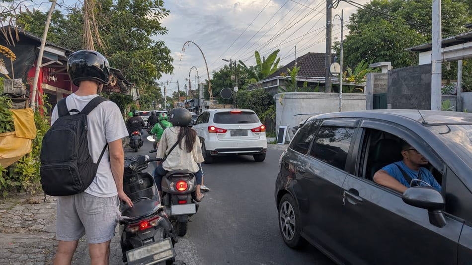 Scooters and cars moving through everyday Bali traffic