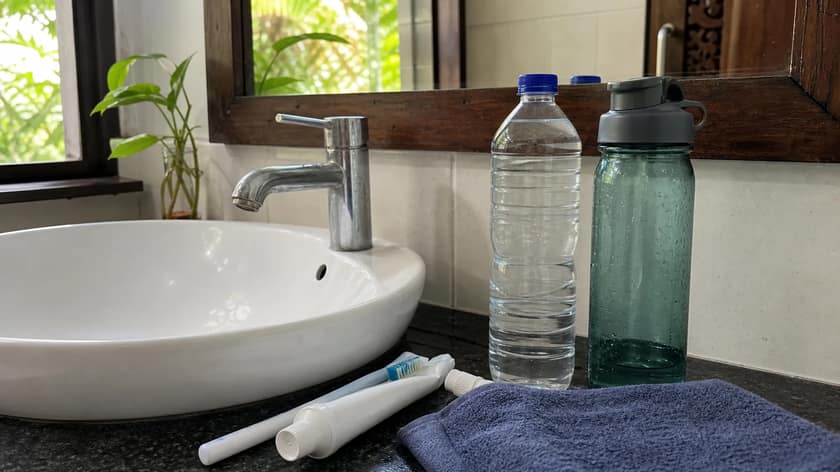 Reusable water bottle beside a travel bag