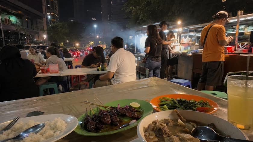 Jakarta street food dishes on a casual table at night