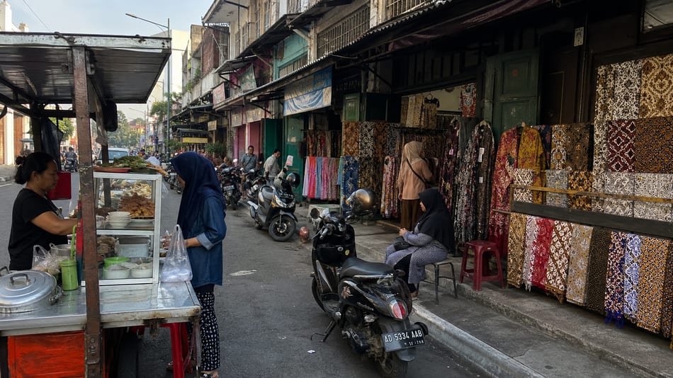 Batik fabric and food stalls in an everyday Solo market scene