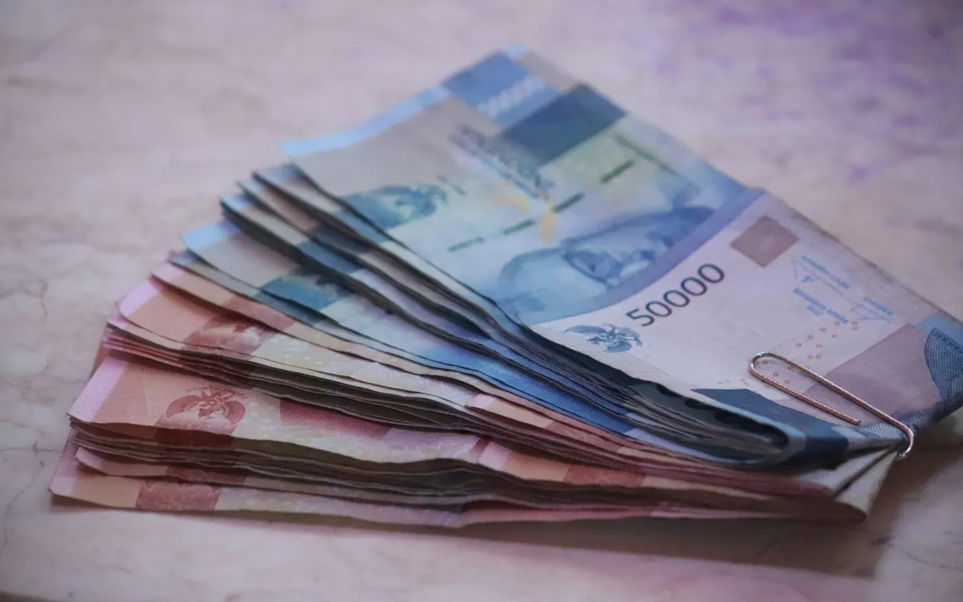Indonesian rupiah cash for Bali travel budget planning Folded Indonesian rupiah banknotes used for Bali travel budget planning