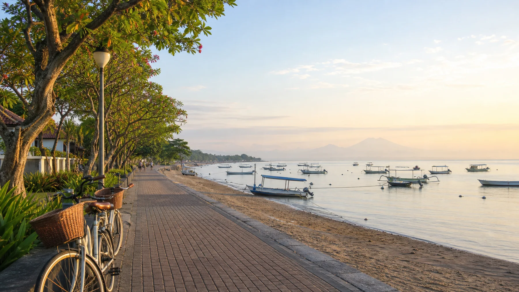 Sanur beachfront promenade with bicycles, calm water and moored boats