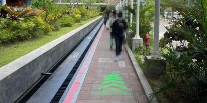 Grab official DPS image showing the pedestrian route toward the motorcycle parking hallway.