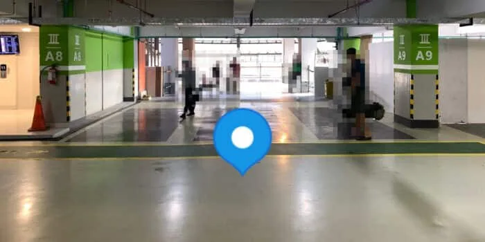 Grab official DPS image showing the domestic GrabCar pickup point in the parking building at Bali Airport.