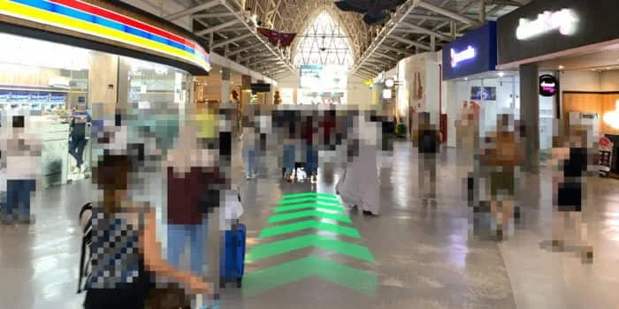 Grab official DPS image showing the domestic route toward Indomaret and the escalator at Bali Airport.