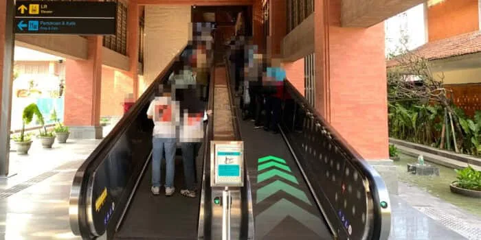 Grab official DPS image showing the escalator to the domestic GrabCar pickup point.