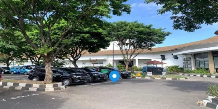 Grab official DPS image showing the GrabCar Premium domestic pickup point at Bali Airport.