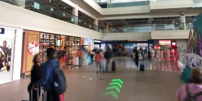 Grab official DPS image showing the international arrivals walking route near WHSmith at Bali Airport.