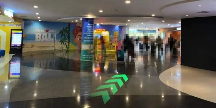 Grab official DPS image showing the international arrivals route near Starbucks at Bali Airport.