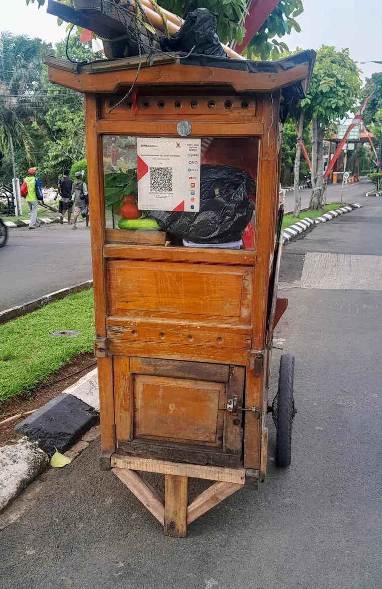 Indonesian food cart with a QRIS payment code displayed on the window